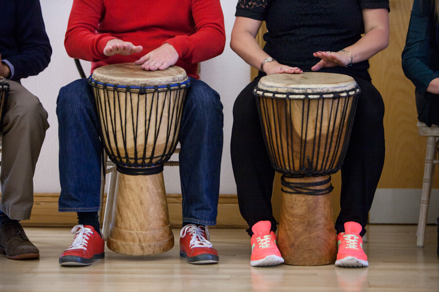 Two people playing the bongos, we don't see their heads.