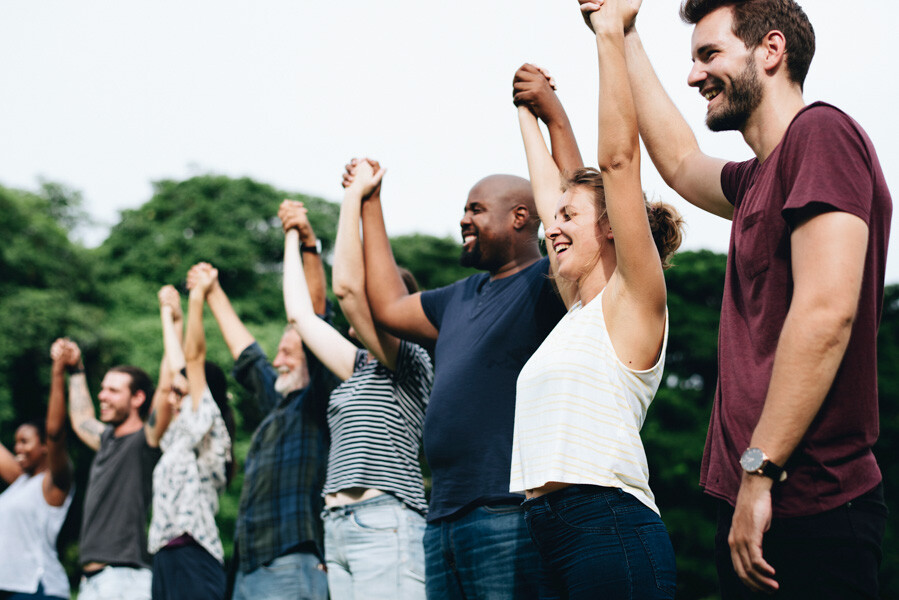 People raising held hands, stood together in a line